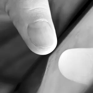 Black and white close-up of a thumb touching a hand.