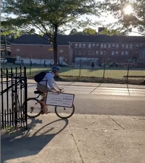 Tevis biking home with a giant novelty check.